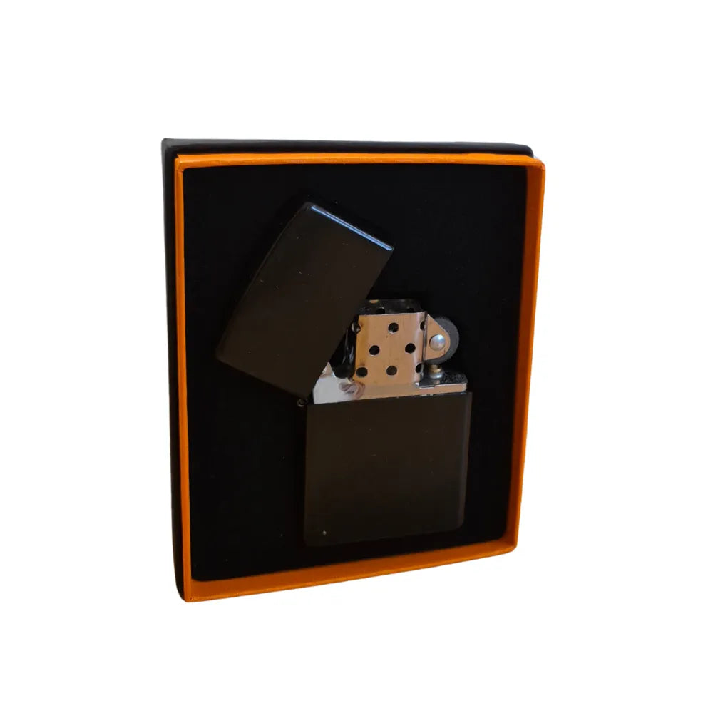 Black flip-top lighter with metallic accents in a black box on a white background