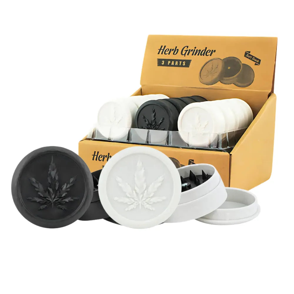 Soft touch plastic herb grinders in black and white with cannabis leaf design